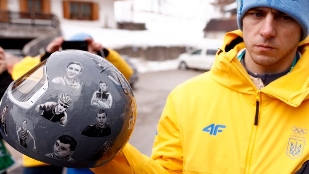Ukraine’s skeleton racer Vladyslav Heraskevych holds his helmet, which depicts victims of his country’s war with Russia, in Cortina d'Ampezzo on February 12, 2026.