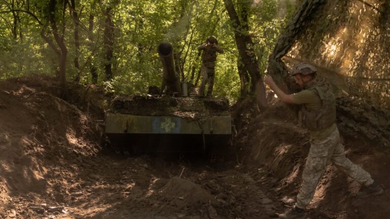 Ukrainian servicemen cover self-propelled artillery 2S7 Pion after firing toward Russian positions, in an undisclosed area in the eastern Donetsk region on August 8, 2024.