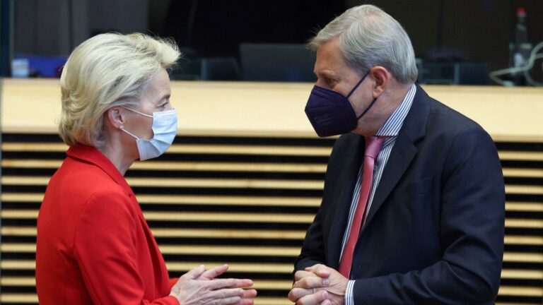 European Commission President Ursula von der Leyen (L) speaks with EU Commissioner for Budget Johannes Hahn (R) as they attend a meeting of the College of Commissioners at the Berlaymont, in Brussels on October 13, 2021.