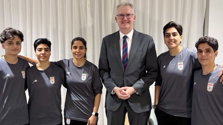 Five members of the Iranian women's football team with Australian Home Affairs Minister Tony Burke