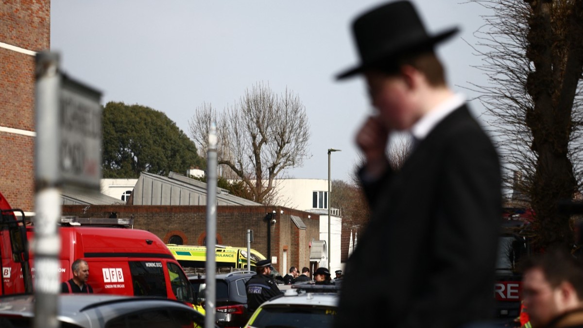 Local residents gather in the Golders Green neighbourhood of north London on March 23, 2026, after volunteer ambulances (behind C) run by a Jewish organisation were set on fire overnight.