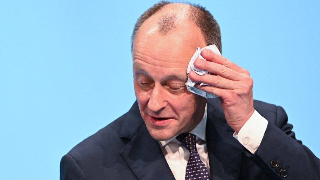 German Chancellor and CDU leader Friedrich Merz wipes his face as he adresses the audience during an election campaign event in Stockach on March 6, 2026.