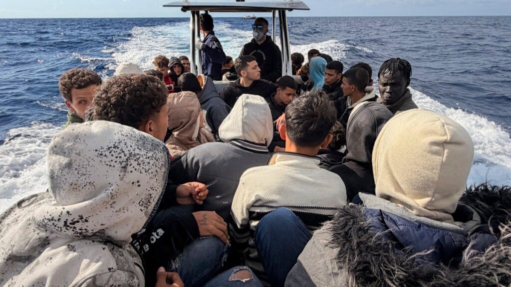 Locals, helping the Greek Coast Guard in their rescue operation, navigate towards the south coast of Crete, on November 18, 2025, aboard of a rubber boat with migrants.