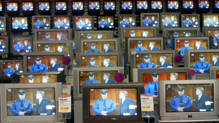 TV monitors on display in a Prague shop show Karel Srba (R), former Foreign Ministry secretary sentenced in June 2003 in Prague to eight years in jail for plotting to kill in July 2002 an investigative Czech journalist, Sabina Slonková, entering in the dock 30 October 2003 in the Prague Appeal Court.