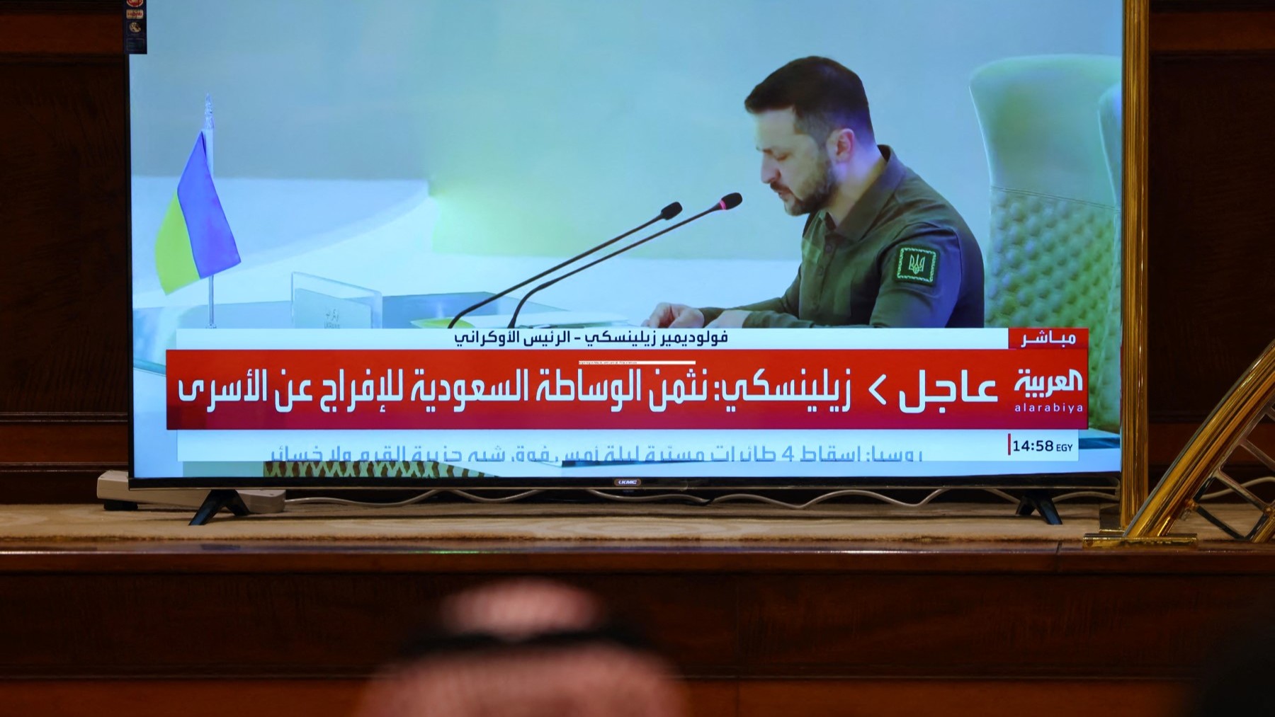 Media delegates watch Ukraine's President Volodymyr Zelensky addressing the Arab League Summit in Jeddah on May 19, 2023.