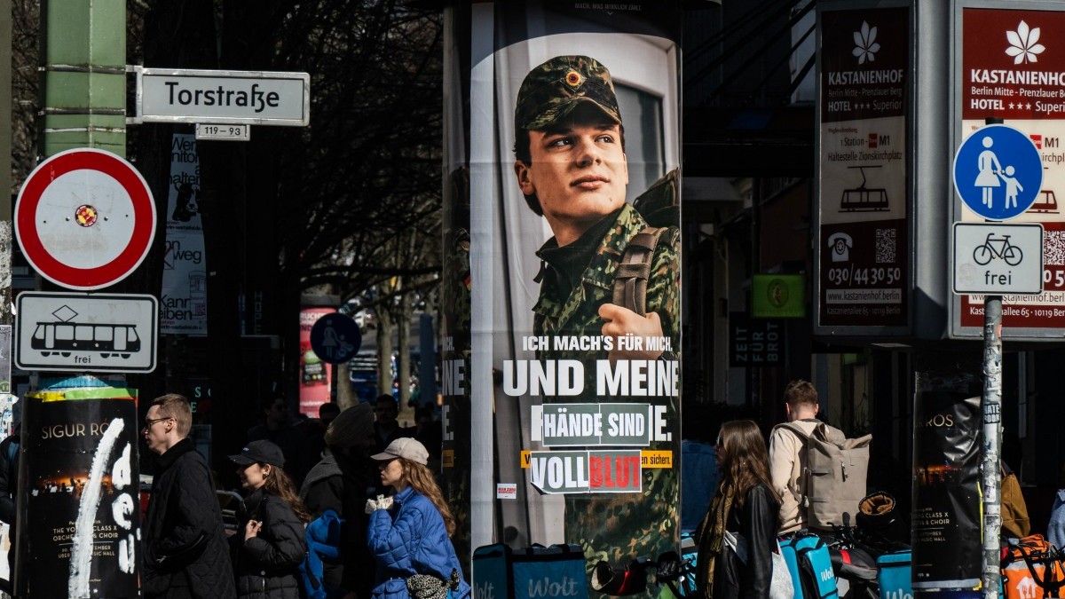 An advertising poster for the Bundeswehr is altered to read: “...and my hands are covered in blood,” in Berlin on March 22, 2026.
