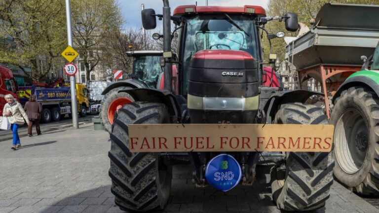 A woman walks past tractors blocking O’Connell Street in the centre of the city, as protests continue for a third day against the rising cost of fuel due to the Middle East crisis, in central Dublin on April 9, 2026.