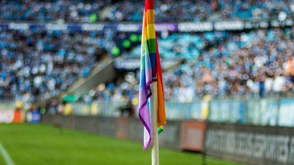 Illustration gender politics in sports (rainbow flag on football pitch (Unsplash)