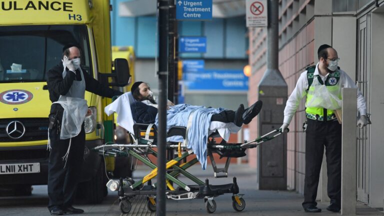 Volunteers from the Hatzola Ambulance service wheel a patient into the Royal London Hospital in London on March 29, 2020, during the COVID-19 pandemic.