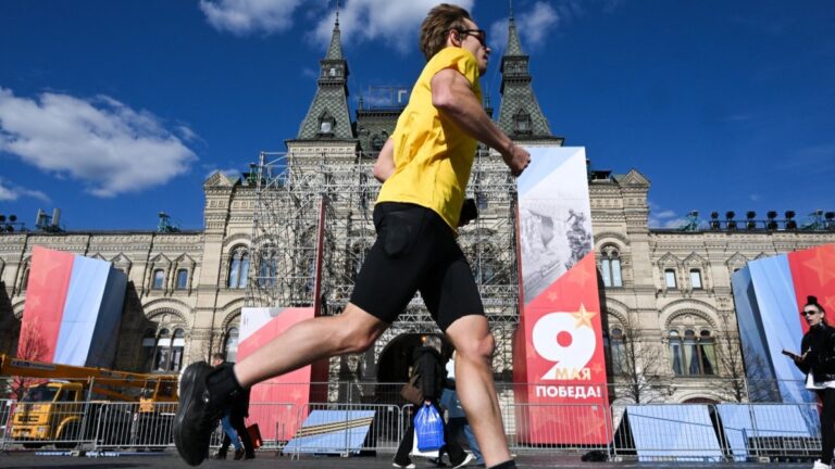 A man jogs along Red Square adorned with first Victory Day decorations in central Moscow on April 22, 2026.