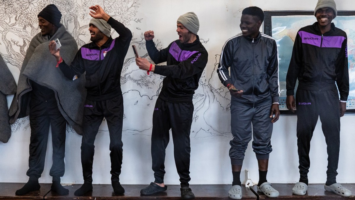 Migrants cheer during a football game onboard the rescue ship Ocean Viking operated by the NGO SOS Mediterranee, as it sails in the Mediterranean Sea toward Palermo, southern Italy, on January 18, 2026.
