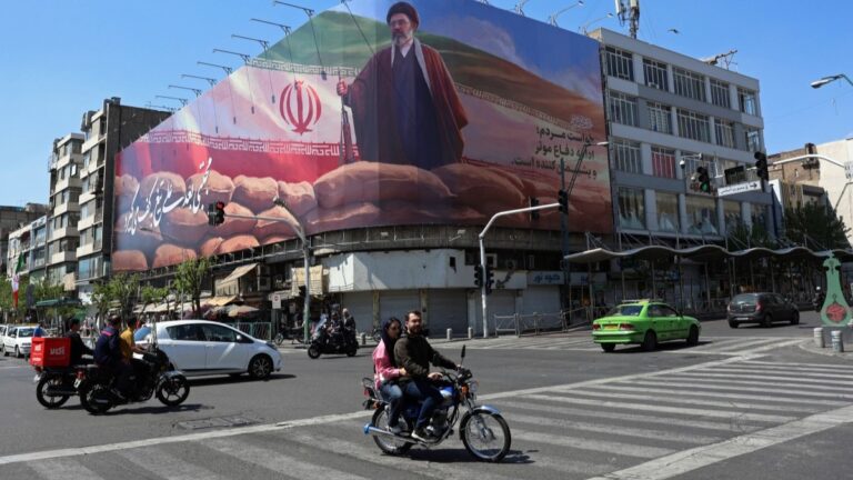 Motorists drive past a giant billboard of Iran’s Supreme Leader Ayatollah Mojtaba Khamenei, along a street in Tehran, on April 10, 2026.
