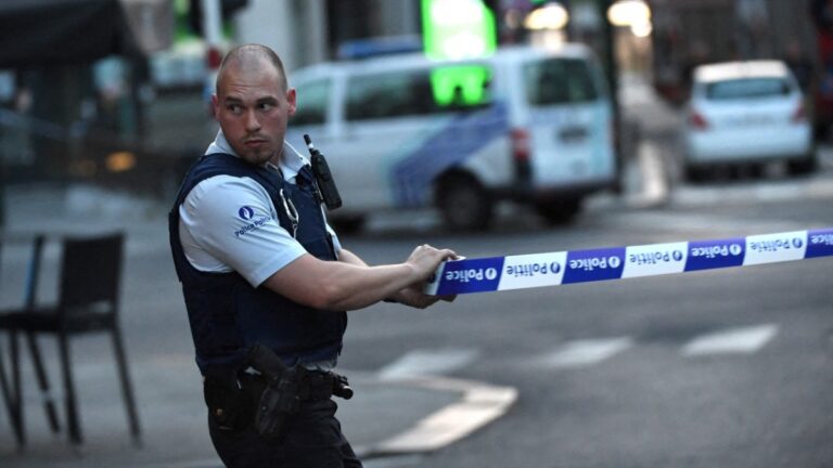 A police official uses tape as he cordons off an area on a street outside the central railway station in Brussels on June 20, 2017, after an explosion in the Belgian capital.