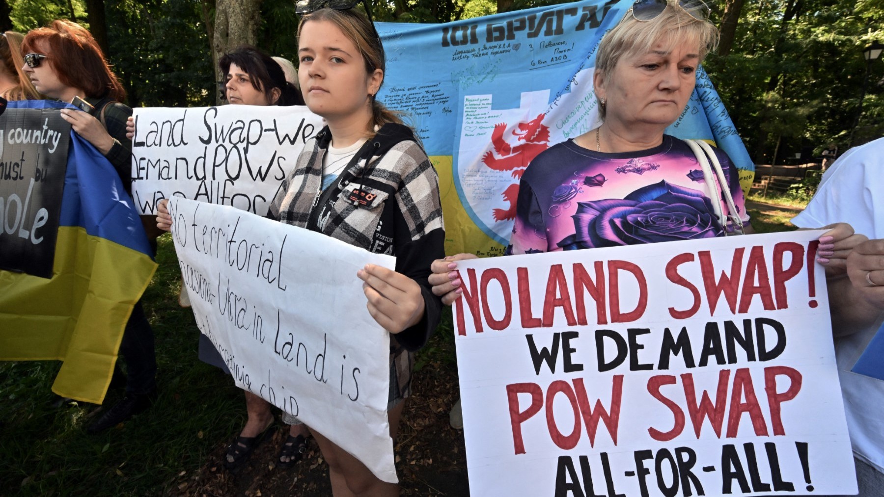 Protestors hold slogans during a demonstration against the idea of territorial swap and to demand prisoners exchange between Ukraine and Russia, outside the U.S. embassy in Kyiv on August 15, 2025, ahead of Trump-Putin talks in Alaska.