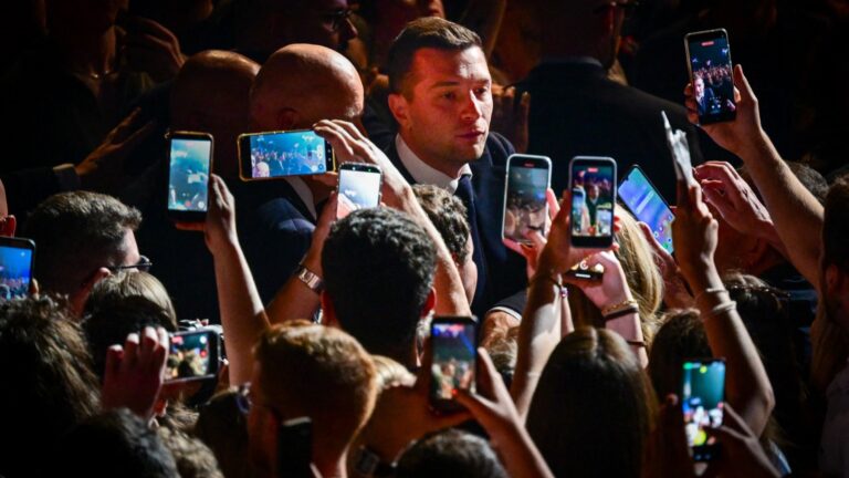 Rassemblement National President Jordan Bardella walks through a crowd of supporters as he arrives to deliver a speech during a rally in Mâcon on May 1, 2026.