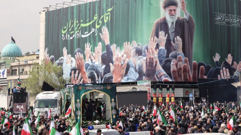Iranians gather beside a billboard depicting Iran’s slain supreme leader Ayatollah Ali Khamenei as they attend the funerals of Iran's Revolutionary Guards Corps (IRGC) commanders.