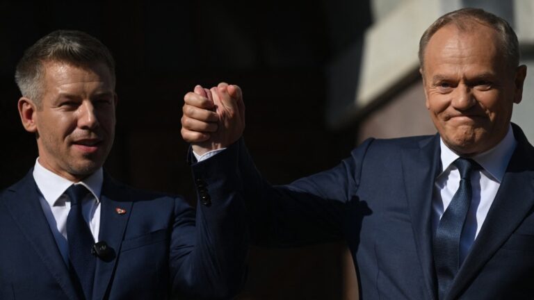 Poland’s Prime Minister Donald Tusk and Hungary’s Prime Minister Péter Magyar hold hands during a rally in Gdansk on May 20, 2026.