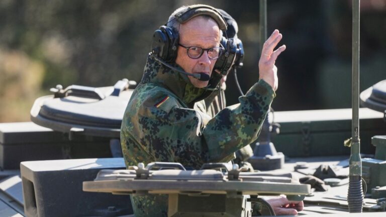 German Chancellor Friedrich Merz waves as he is driven in a GTK Boxer tank at the German army barracks in Münster, northern Germany, on April 30, 2026.