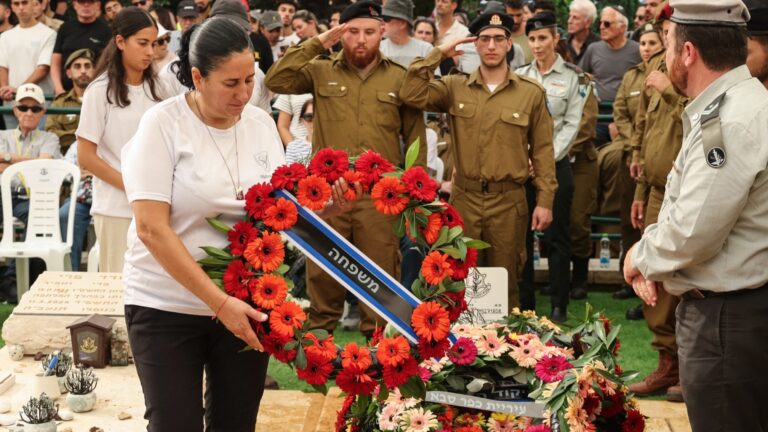 The mother of Oz Daniel, a 19-year-old Israeli corporal killed by Hamas terrorists in the October 7, 2023 attacks on southern Israel lays a wreath of flowers on his grave during his funeral at a military cemetery in Kfar Saba on November 6, 2025.