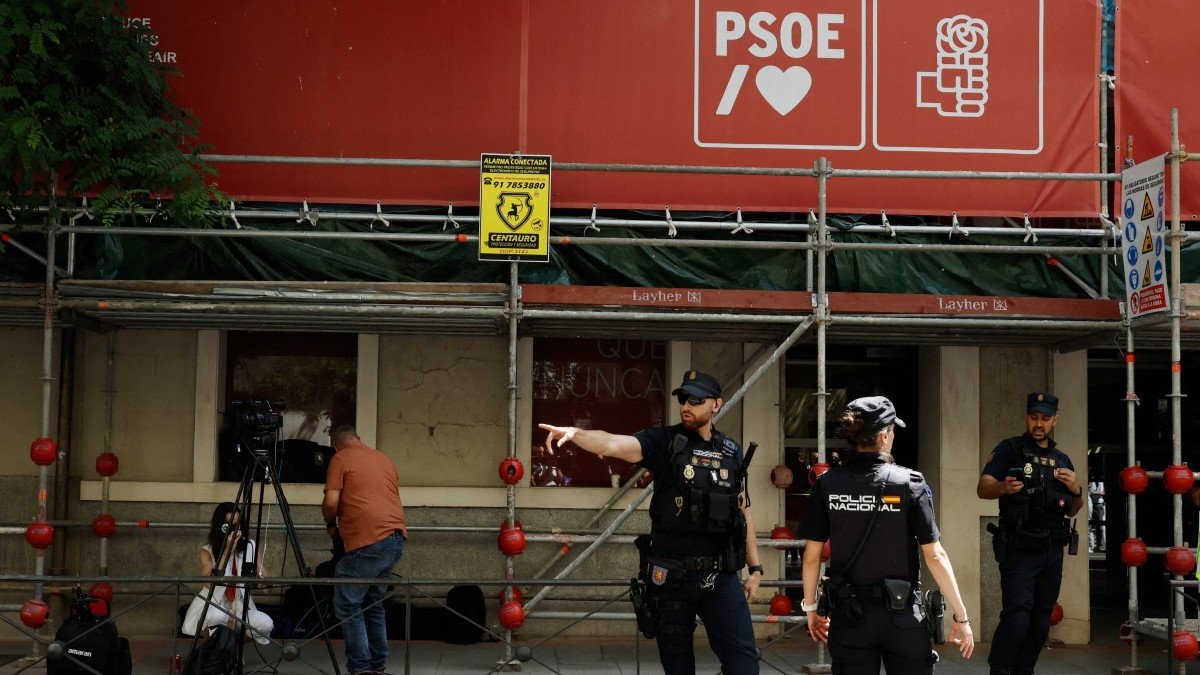 Spanish National Police officers stand guard outside the ruling Spanish Socialist Party (PSOE) headquarters after agents from the UCO, the Civil Guard unit specializing in complex and sensitive investigations, entered the premises to demand documents, in Madrid, on May 27, 2026.