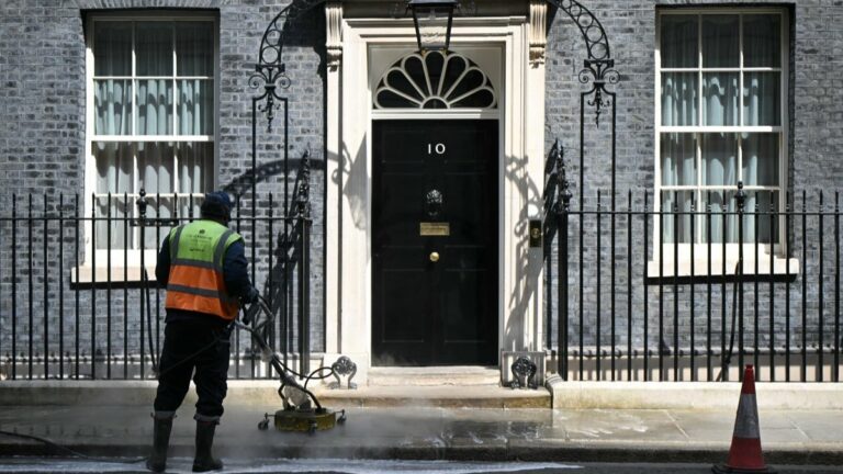 Workers clean the street outside the door to 10 Downing Street, the official residence of Britain’s Prime Minister, Labour leader Keir Starmer, in central London on May 9, 2026.