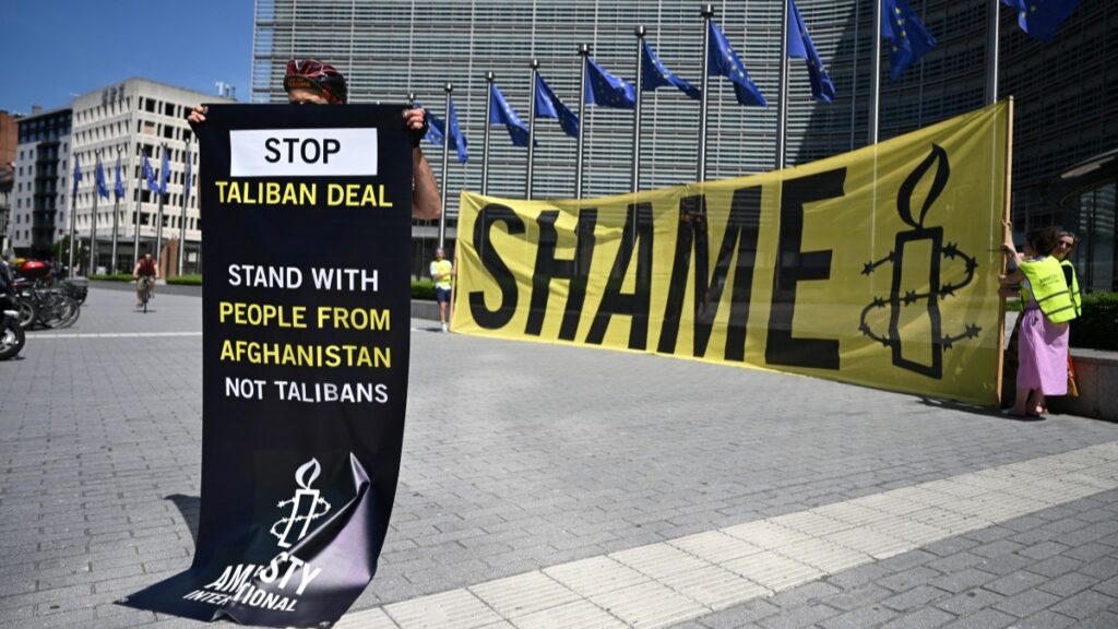 An Amnesty International activist hold a banner reading “Stop Taliban deal" in front of the EU Commission headquarters to protest against a meeting with a Taliban delegation in Brussels on June 23, 2026.