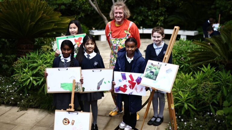 British artist Grayson Perry poses with children from a local primary school in the Tate Britain Garden on the press day ahead of the 2026 RHS Chelsea Flower Show in London on May 18, 2026.