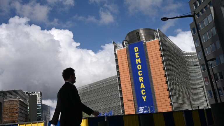 A pedestrian walks past the Berlaymont building, headquarters of the European Commission, in Brussels on April 20, 2026.