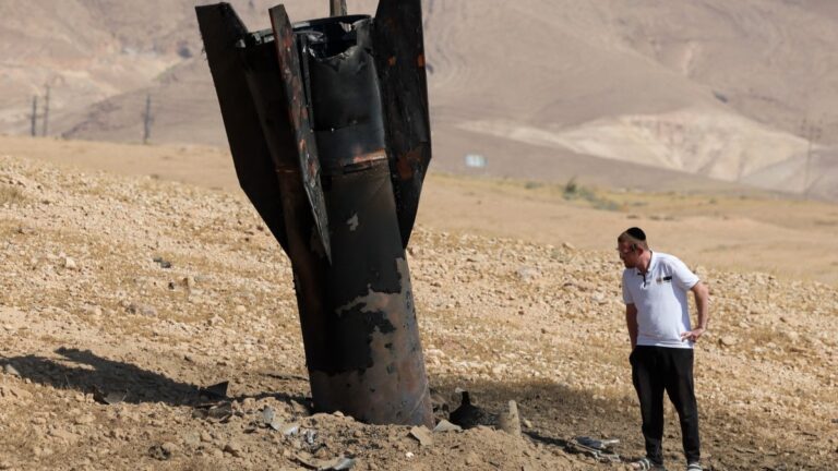 A man checks a fallen rocket half-buried in the ground on the outskirts of Jericho on June 8, 2026, following Iranian and Iran-backed Houthi rebel attacks.