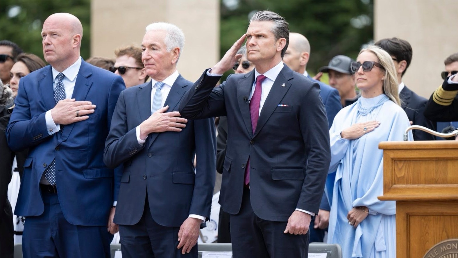 U.S. Secretary of War Pete Hegseth salutes, standing alongside U.S. Ambassador to NATO Matthew Whitaker (L1), U.S. Ambassador to France Charles Kushner (L2), and his wife, Jennifer Rauchet (R) on June 6, 2026 in Normandy, France.