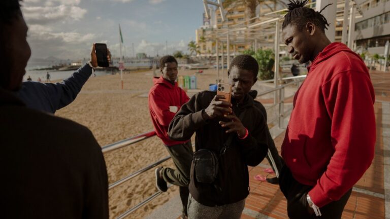 Senegalese men who recently arrived in Gran Canaria after crossing the Atlantic route from Gambia take photos on the beach of Las Canteras in Las Palmas on January 19, 2026.