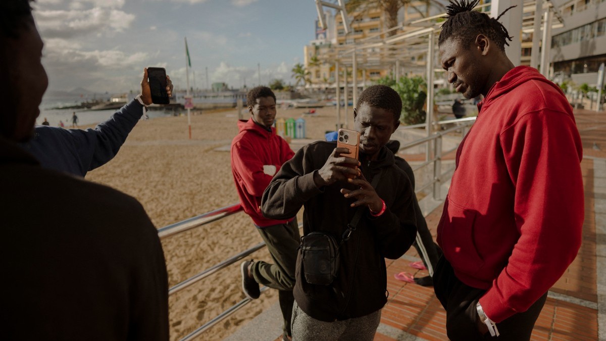 Senegalese men who recently arrived in Gran Canaria after crossing the Atlantic route from Gambia take photos on the beach of Las Canteras in Las Palmas on January 19, 2026.