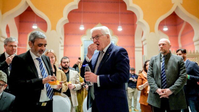 German President Frank-Walter Steinmeier (R) breaks the fast with Imam Amir Aziz (L) as he joins fasting Muslims during an Iftar dinner at the Wilmersdorf mosque, during the Muslim holy month of Ramadan in Berlin on March 12, 2025.
