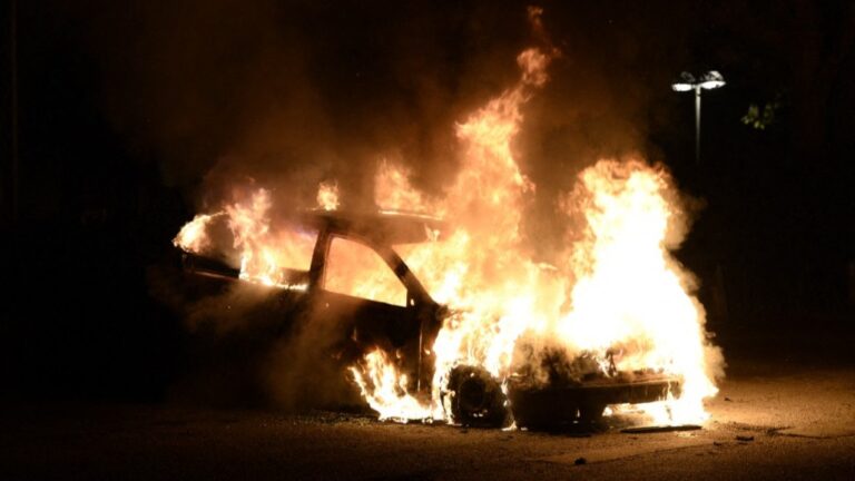Firemen extinguish a burning car in Kista, Sweden, after youths rioted in different suburbs around Stockholm on May 21, 2013.
