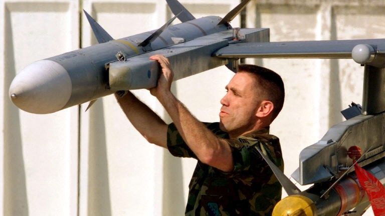 A U.S. soldier fixes a missile on the wing of a F-16 fighter plane at Aviano air base in the North of Italy Thursday April 1.