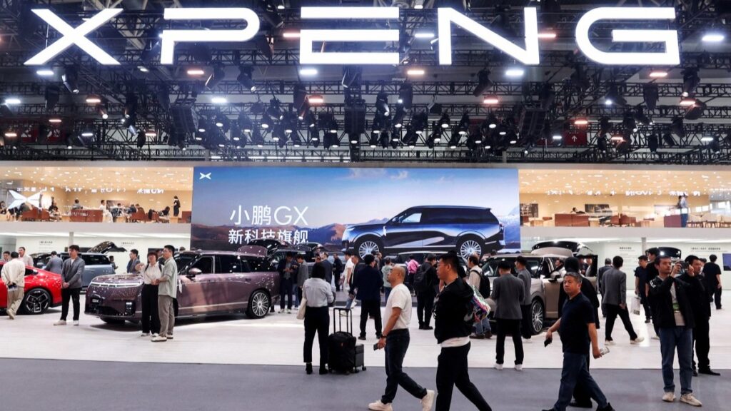 Visitors walk past the booth of Chinese automaker XPeng at the Beijing Auto Show in Beijing on April 25, 2026.