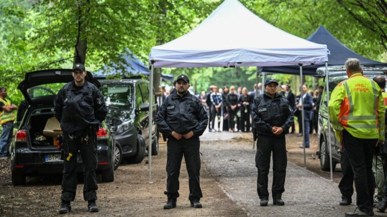 Police stand guard as German Chancellor Friedrich Merz (behind, hidden) and German Interior Minister Alexander Dobrindt visit on July 26, 2026 the site in Tiergarten park in Berlinwhere a vehicle crashed into a crowd near Berlin’s annual Christopher Street Day Pride parade on the evening of June 25.