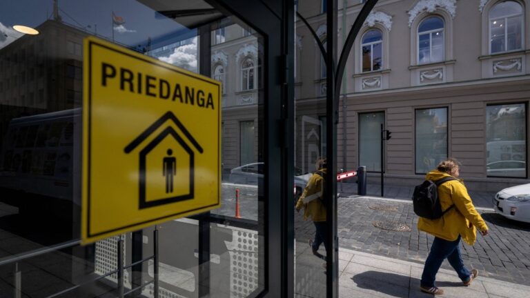 People pass the entrance to an underground car park marked as a shelter with a yellow sticker reading “Priedanga” (Shelter) on Gediminas Prospect in central Vilnius on May 28, 2026.