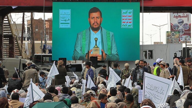 Shiite Muslim Yemenis listen to a speech by Huthi leader Abdul-Malik al-Huthi being broadcasted on a giant screen during a ceremony commemorating Ashura, in Sanaa on June 25, 2026.
