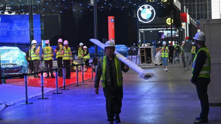 Workers assemble the stand for German carmaker BMW ahead of the Beijing Auto Show 2026 at the China International Exhibition Center in Beijing on April 22, 2026.