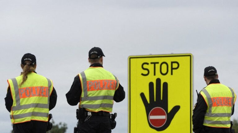 Police officers wait for passport control at a highway slip road at the German-Austrian border near the village of Passau, southern Germany, on September 14, 2015.