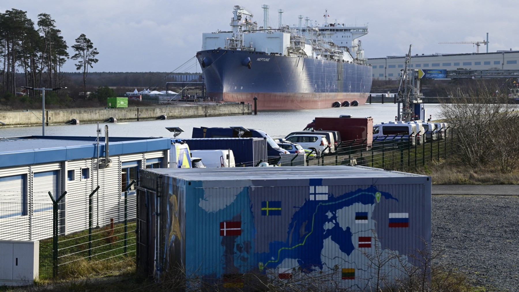Floating Storage and Regasification Unit (FSRU) Neptune is pictured behind a container painted with a map showing the Nord Stream 2 gas pipeline, which was expected to deliver Russian gas to European households, in Lubmin’s industrial park, northeastern Germany.