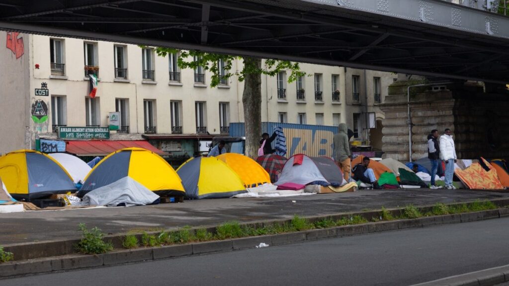 Tents at a temporary migrant camp under an elevated section of Metro line 2, in the La Chapelle district of Paris on May 7, 2026