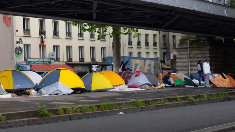 Tents at a temporary migrant camp under an elevated section of Metro line 2, in the La Chapelle district of Paris on May 7, 2026