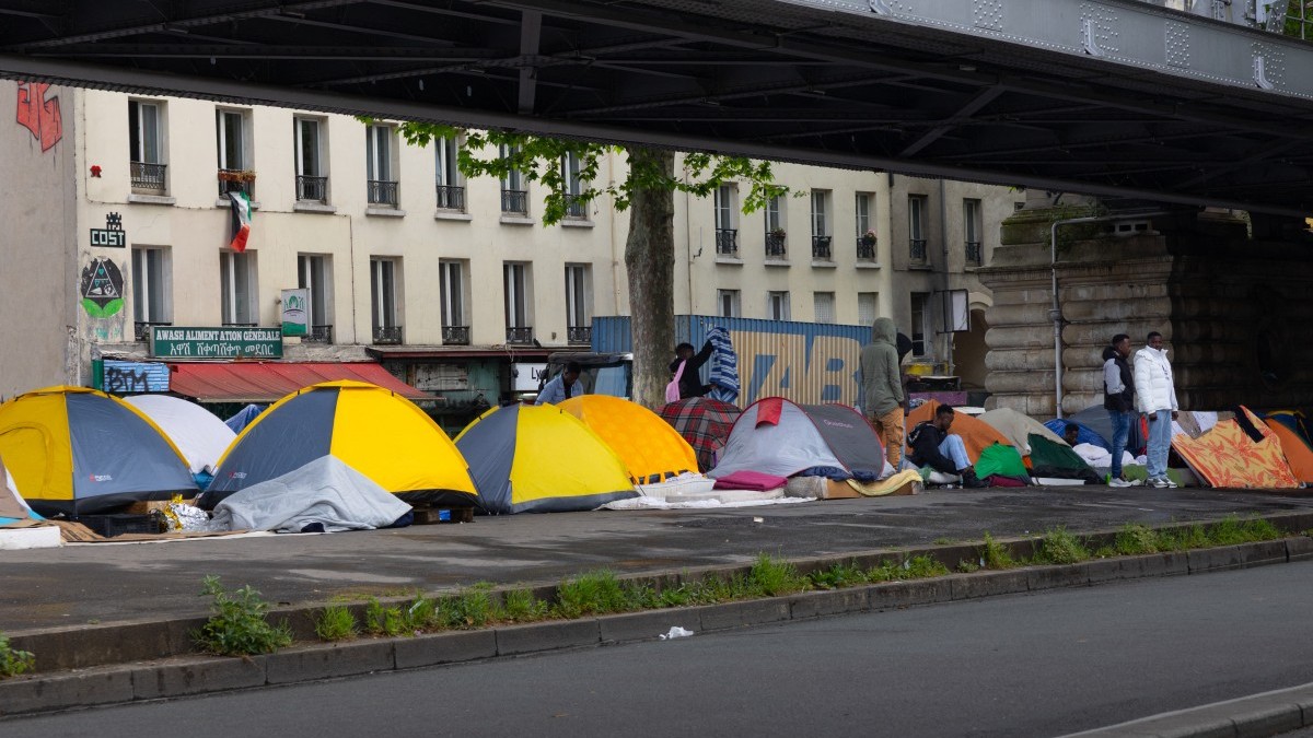 Tents at a temporary migrant camp under an elevated section of Metro line 2, in the La Chapelle district of Paris on May 7, 2026