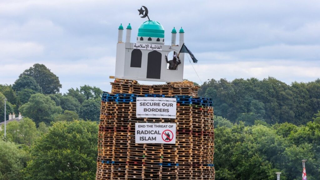 A bonfire made of wooden pallets with a replica of a mosque at the top is pictured in Moygashel, County Tyrone, Northern Ireland on July 9, 2026, to be lit in the run-up to Orange Order traditional parades on July 12 that mark a Protestant victory over Catholics in 1690.