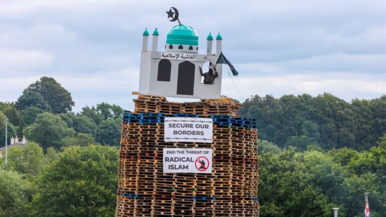 A bonfire made of wooden pallets with a replica of a mosque at the top is pictured in Moygashel, County Tyrone, Northern Ireland on July 9, 2026, to be lit in the run-up to Orange Order traditional parades on July 12 that mark a Protestant victory over Catholics in 1690.