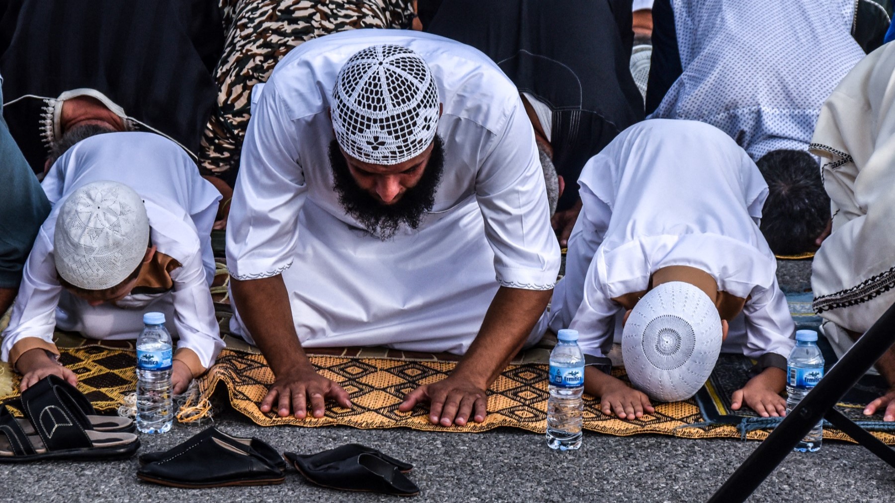 A man and two children bend as they pray during the Muslim religious celebration of Eid al-Adha in the Spanish enclave of Ceuta, on September 1, 2017.