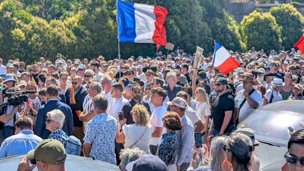 Attendees hold a banner depicting a portrait of Louis, a teenager killed in an ambush, during a tribute march to the 17 year-old boy in Narbonne, southerm France on July 5, 2026.