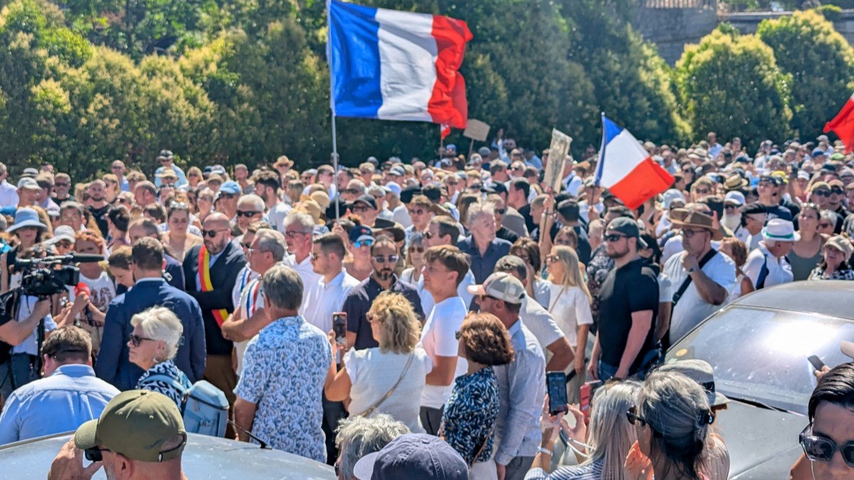 Attendees hold a banner depicting a portrait of Louis, a teenager killed in an ambush, during a tribute march to the 17 year-old boy in Narbonne, southerm France on July 5, 2026.